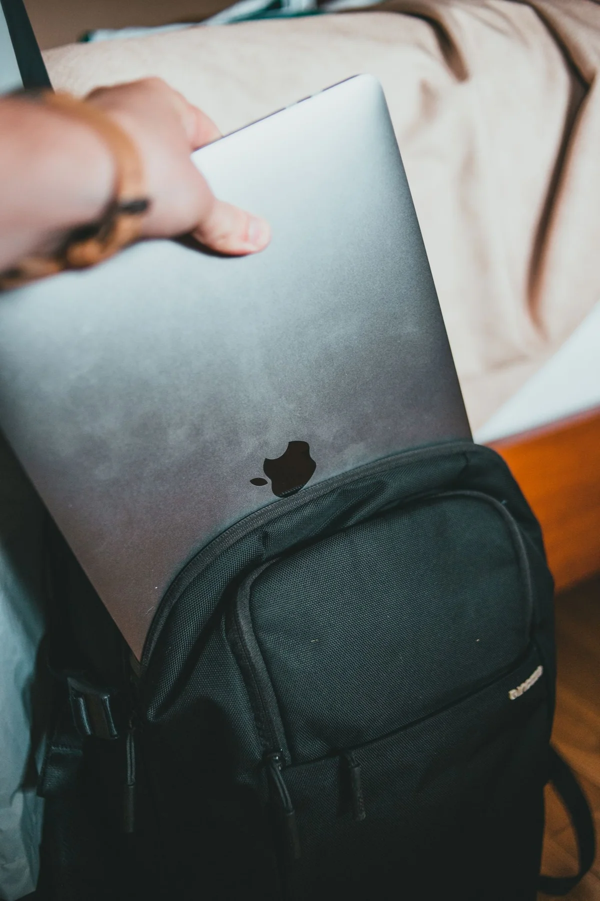 Laptop being placed into a backpack